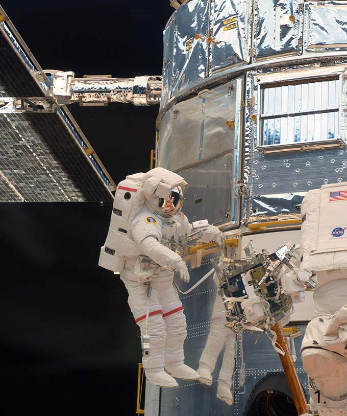 NASA의 우주인들이 우주 공간으로 나가 허블 우주망원경을 수리하는 모습